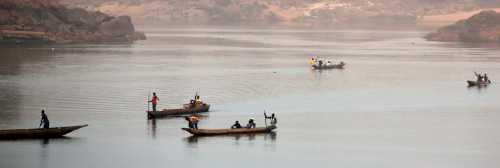 Wooden canoes cross the Ubangi River from the Democratic Republic of Congo to the capital Bangui, Central African Republic, February 15, 2016. Picture taken on February 15, 2016. REUTERS/Siegfried Modola  - GF10000318371