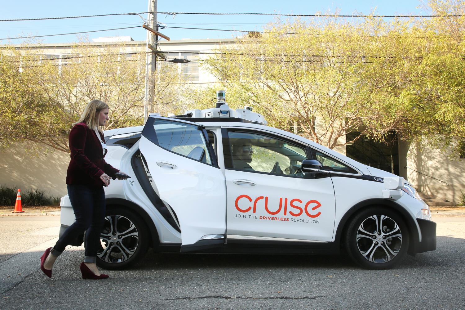 A woman gets in a self-driving Chevy Bolt EV car during a media event by Cruise, GMs autonomous car unit, in San Francisco.
