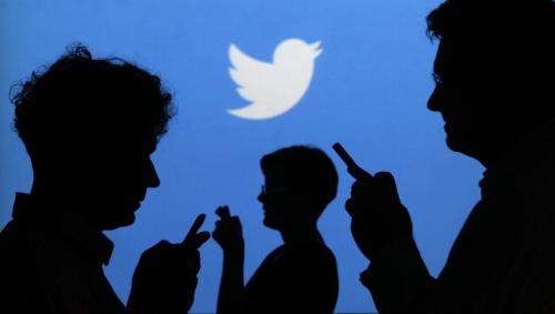 People holding mobile phones are silhouetted against a backdrop projected with the Twitter logo in this illustration picture taken in  Warsaw September 27, 2013. Twitter Inc, the eight-year-old online messaging service, gave potential investors their first glance at its financials on Thursday when it publicly filed its IPO documents, setting the stage for one of the most-anticipated debuts in over a year. Picture taken September 27.  REUTERS/Kacper Pempel (POLAND - Tags: BUSINESS TELECOMS LOGO) - BM2E9A410KY01