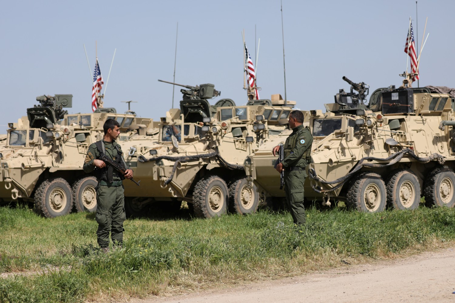 Kurdish fighters from the People's Protection Units (YPG) stand near U.S military vehicles in the town of Darbasiya next to the Turkish border, Syria April 29, 2017. Picture taken April 29, 2017. REUTERS/Rodi Said - RC16C054E9B0