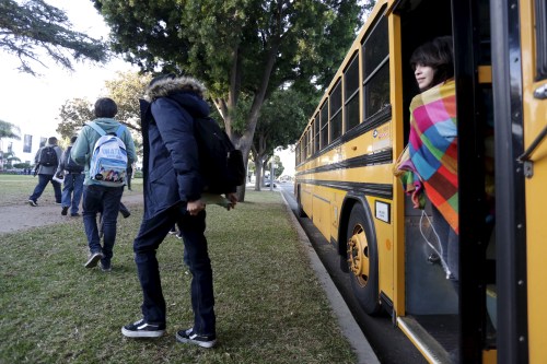 Students exit a bus as they arrive at Venice High School in Los Angeles.