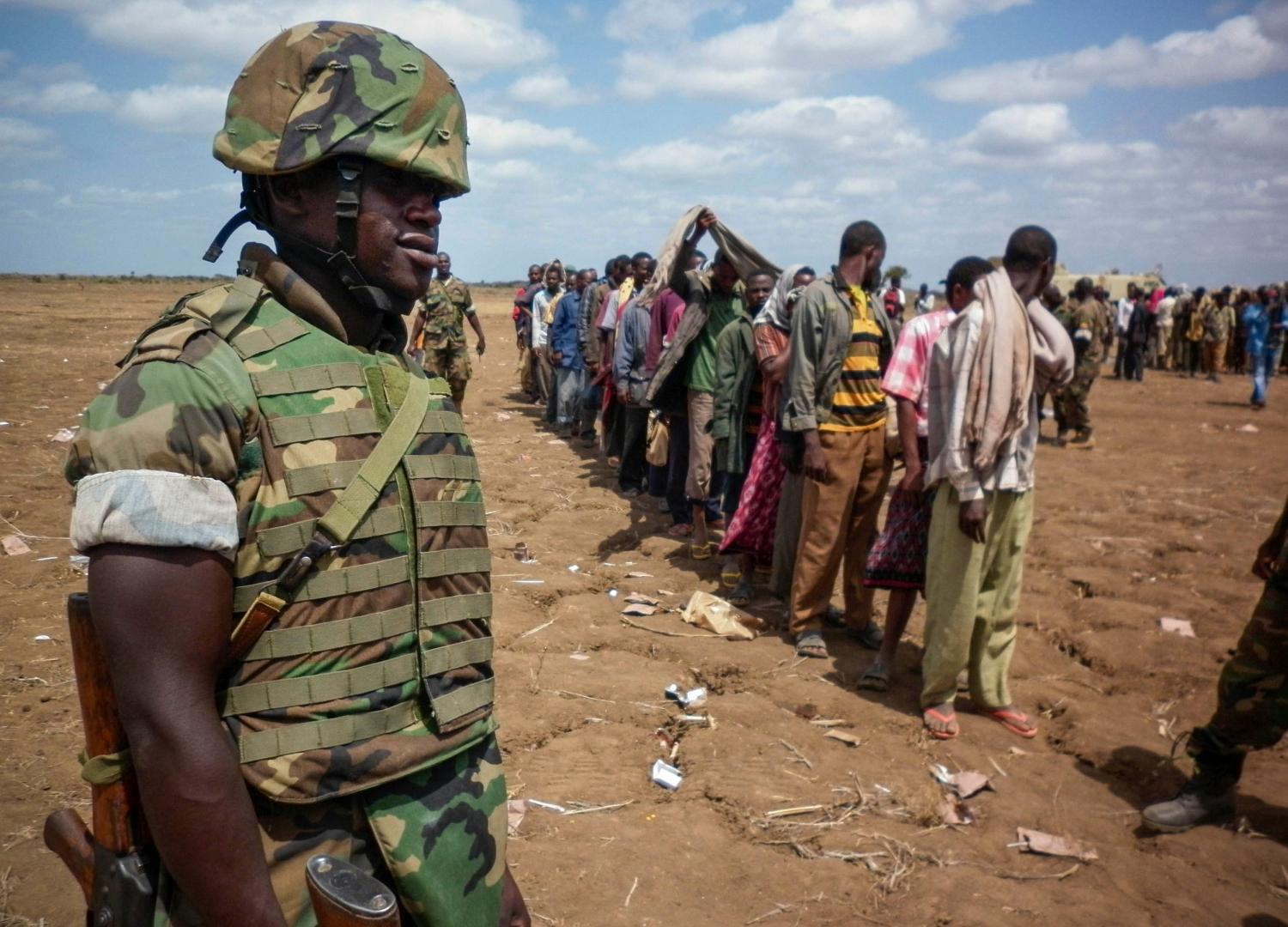 DATE IMPORTED: September 23, 2012 A Ugandan soldier from the African Union Mission in Somalia (AMISOM) watches as defected members of Islamist militant group al Shabaab walk after giving themselves up to the African Union AMISOM forces in Garsale, approximately 10km from the town of Jowhar, 80km north of Mogadishu, in this September 22, 2012 handout picture made available by the African Union-United Nations Information Support Team on September 23, 2012. Islamist rebels said they shot dead a Somali lawmaker in Mogadishu on Saturday and threatened to kill every legislator in the country. The African Union Mission in Somalia (AMISOM) force said, however, there were signs of deepening internal rifts within al Shabaab. More than 200 rebels defected near the town of Jowhar on Saturday, AMISOM said. REUTERS/AU-UN IST/Abukar Albadri/Handout (SOMALIA - Tags: CIVIL UNREST POLITICS) FOR EDITORIAL USE ONLY. NOT FOR SALE FOR MARKETING OR ADVERTISING CAMPAIGNS. THIS IMAGE HAS BEEN SUPPLIED BY A THIRD PARTY. IT IS DISTRIBUTED, EXACTLY AS RECEIVED BY REUTERS, AS A SERVICE TO CLIENTS