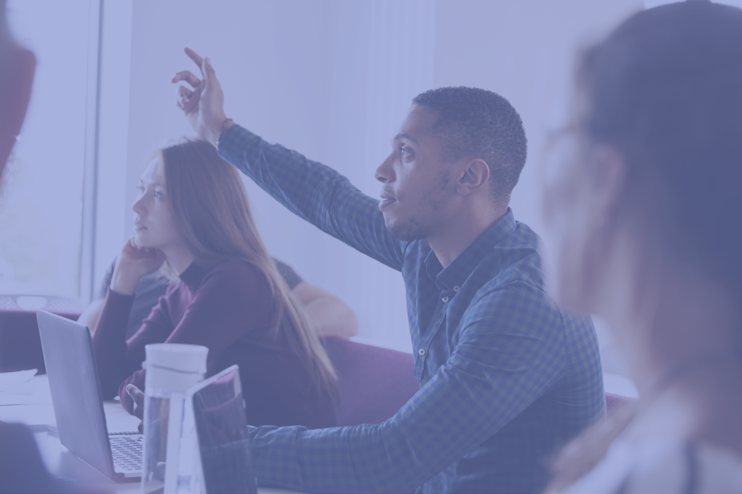 Student raising hand in a classroom