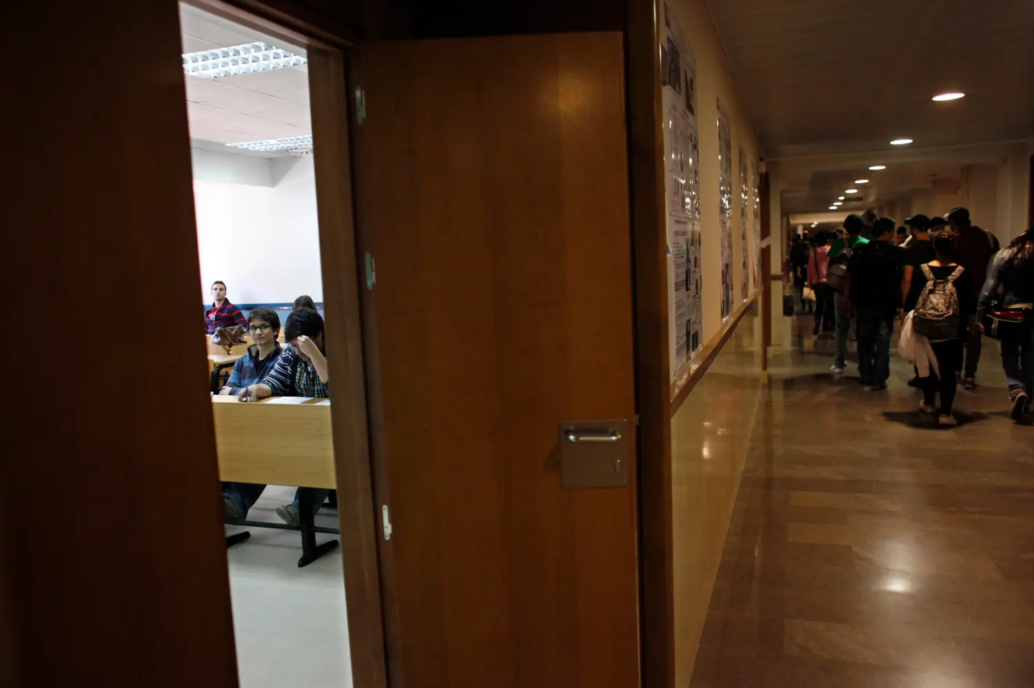 A handful of students attend class as other student picketers walk the hallways at Madrid's Complutense University during a general teachers' strike against educational cuts imposed by the Spanish government May 22, 2012. Spanish teachers went on strike on Tuesday to protest against cuts in education spending that labour unions say will put 100,000 substitute teachers out of work but that the government says are needed to tackle the euro zone debt crisis. REUTERS/Susana Vera (SPAIN - Tags: EDUCATION CIVIL UNREST) - GM1E85M1LOP01