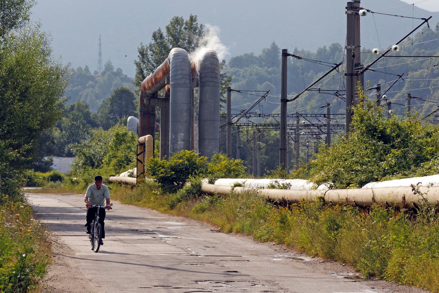 A man rides a bicycle along an empty road in Aninoasa, 330 km (202 miles) west of Bucharest July 31, 2013. If joining the European Union was supposed to lift Romania out of poverty, in Aninoasa, a town of 4,800 people in the mountainous Jiu Valley region, it has yet to work. Six years after Romania's accession to the EU, not only is Aninoasa still poor - it has also become the first town in Romania to file for insolvency. Picture taken July 31, 2013. REUTERS/Bogdan Cristel (ROMANIA - Tags: SOCIETY BUSINESS EMPLOYMENT POVERTY) ATTENTION EDITORS: PICTURE 21 OF 23 FOR PACKAGE 'ROMANIA'S BANKRUPT TOWN'. SEARCH 'ANINOASA' FOR ALL IMAGES - GM1E98V1AG501