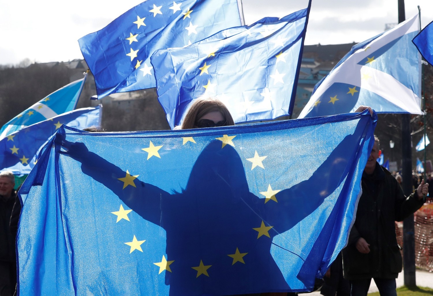 A protesters waves an EU flag as others wave Saltires as they take part in a demonstration to demand a vote on the Brexit deal between Britain and the European Union in Edinburgh, Scotland, March 24, 2018. REUTERS/Russell Cheyne - RC176231A500