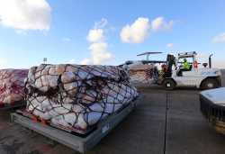 Workers load humanitarian aid from United Nations onto a plane for Syrian families, in Arbil airport, about 350 km (220 miles) north of Baghdad, December 15, 2013. The United Nations sent its first delivery of humanitarian aid by air to Syria from Iraq on Sunday and said it plans to deliver more food and winter supplies to the mainly Kurdish northeast in the next 12 days. The first cargo plane carrying food took off from Arbil in Iraq's northern Kurdistan region and will make a one-hour flight to Hassakeh in Syria. The food supplies over the next 12 days should be able to feed more than 6,000 Syrian families for the rest of December, the U.N.'s World Food Programme said. REUTERS/Stringer (IRAQ - Tags: CONFLICT CIVIL UNREST POLITICS SOCIETY TRANSPORT) - GM1E9CF1TLI01