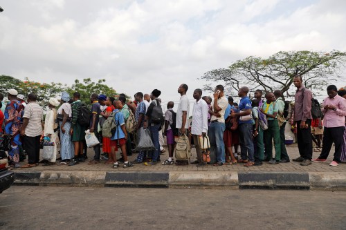 People wait and queue up for commercial transport at a bus stop after the school hours in Ojodu district in Lagos, Nigeria May 31, 2018. REUTERS/Akintunde Akinleye - RC13C752A980