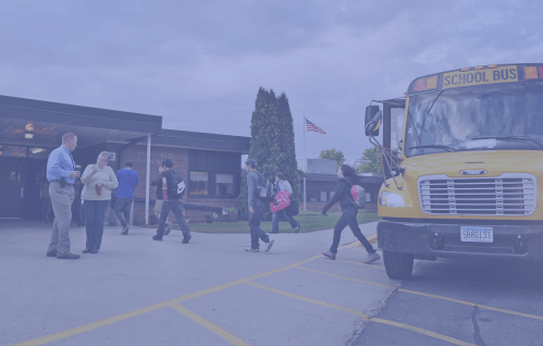 Children walking into school from a bus