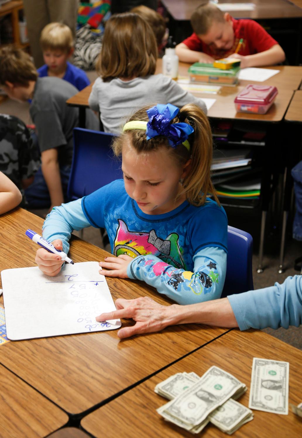 Second grade student Brylee Budde counts the money earned from selling eggs at the Walton Rural Life Center Elementary School, in Walton, Kansas, January 18, 2013. Students at the school do farm chores at the beginning of each school day. The Walton Rural Life Center - a kindergarten through fourth grade  charter school in rural Kansas - uses agriculture to teach students about math, science, economics.  REUTERS/Jeff Tuttle (UNITED STATES - Tags: EDUCATION AGRICULTURE SOCIETY) - TM4E92G12JB01