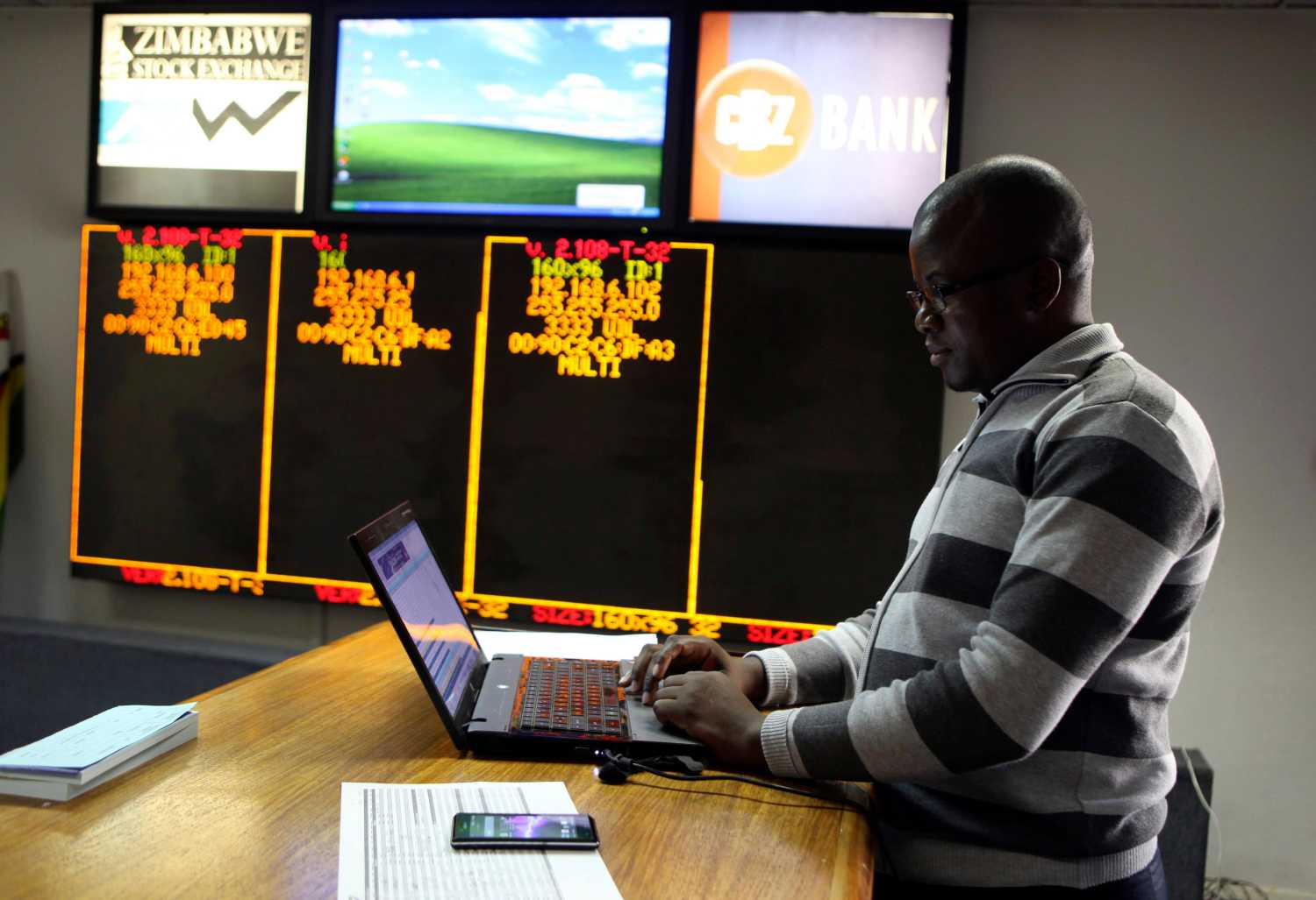 A Zimbabwe Stock Exchange official works on a computer after the close of trade in Harare June 6, 2014. Zimbabwe's stock market has fallen so far from last year's peak that some investors are stepping back in to scoop up consumer-oriented African growth plays. To match Africa investment ZIMBABWE-STOCKS/  REUTERS/Philimon Bulawayo (ZIMBABWE - Tags: BUSINESS) - GM1EA661KIC01