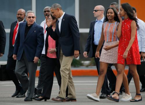 U.S. President Barack Obama and his daughters Malia and Sasha are accompanied by Cuba's President Raul Castro as they walk towards Air Force One at the end of their visit to Cuba, at Havana's international airport, March 22, 2016.  REUTERS/Carlos Barria - TB3EC3M1NKZOF