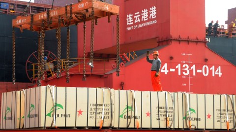 A worker gestures as a crane lifts goods onto a cargo ship, at a port in Lianyungang, Jiangsu province, China May 31, 2018. Picture taken May 31, 2018. REUTERS/Stringer   ATTENTION EDITORS - THIS IMAGE WAS PROVIDED BY A THIRD PARTY. CHINA OUT. - RC180A124BF0