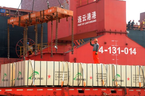 A worker gestures as a crane lifts goods onto a cargo ship, at a port in Lianyungang, Jiangsu province, China May 31, 2018. Picture taken May 31, 2018. REUTERS/Stringer   ATTENTION EDITORS - THIS IMAGE WAS PROVIDED BY A THIRD PARTY. CHINA OUT. - RC180A124BF0