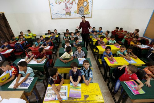 Refugee schoolchildren attend a lesson in a classroom on the first day of the new school
