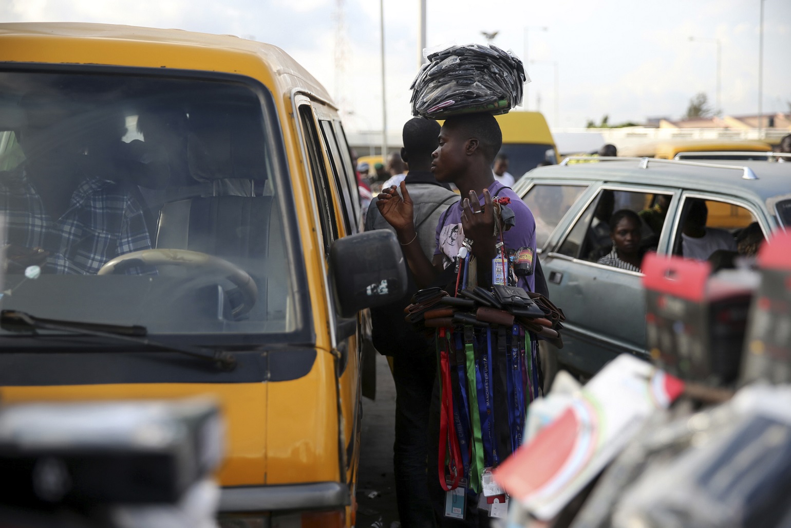 A man hawks his goods at a motor park in the Obalende district of Lagos October 9, 2013. With between 15 million and 21 million people - the upper estimate is the official one, though no one really knows - and generating a third of GDP for Africa's second biggest economy, Lagos has become almost as alluring to yield-hungry investors as it is to the 4,000 or so economic migrants who turn up each day. But it faces a daily challenge just trying to keep up with the pace of population growth, much of it on the edge of water. Nigeria, already pushing 170 million people, will be home to 400 million by 2050, making it the world's fourth most populous country, according to the global Population Reference Bureau (PRB). Lagos will have roughly doubled in size by then, Fashola and demographers agree. Picture taken October 9, 2013. To match Insight LAGOS-MEGACITY/    REUTERS/Akintunde Akinleye (NIGERIA - Tags: SOCIETY BUSINESS EMPLOYMENT) - GM1E9AN0J5R01