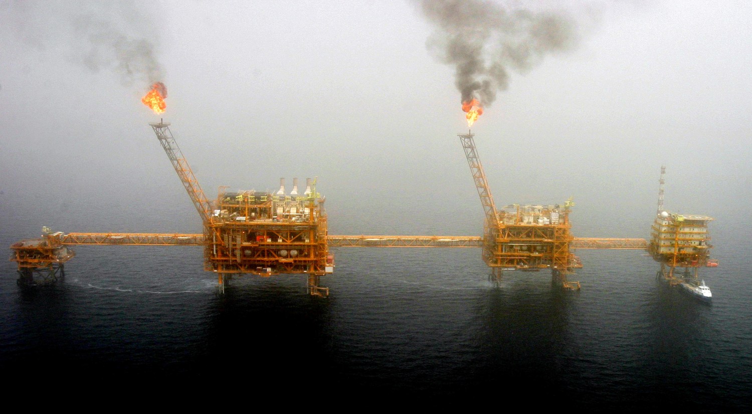 Gas flares from an oil production platform at the Soroush oil fields in the Persian Gulf, south of the capital Tehran, July 25, 2005.  REUTERS/Raheb Homavandi/File Photo - S1AETIFZOIAA