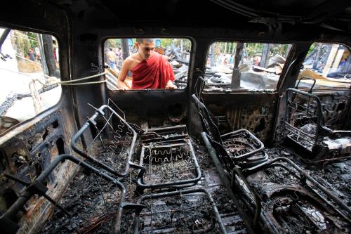 A Buddhist monk looks through the window of a burnt car after Muslims attacked and set fire to a temple in Cox's Bazar October 1, 2012. Bangladesh accused Muslim Rohingya refugees from Myanmar on Monday of involvement in attacks on Buddhist temples and homes in the southeast and said the violence was triggered by a photo posted on Facebook that insulted Islam. REUTERS/Andrew Biraj (BANGLADESH - Tags: RELIGION CIVIL UNREST) - GM1E8A11KYB01