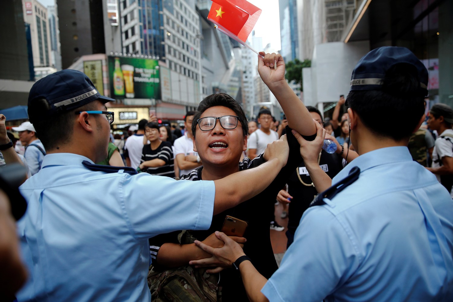 A pro-China supporter is stopped by police as he tries to get closer to pro-democracy supporters during a march. Hong Kong, China July 1, 2017. REUTERS/Damir Sagolj