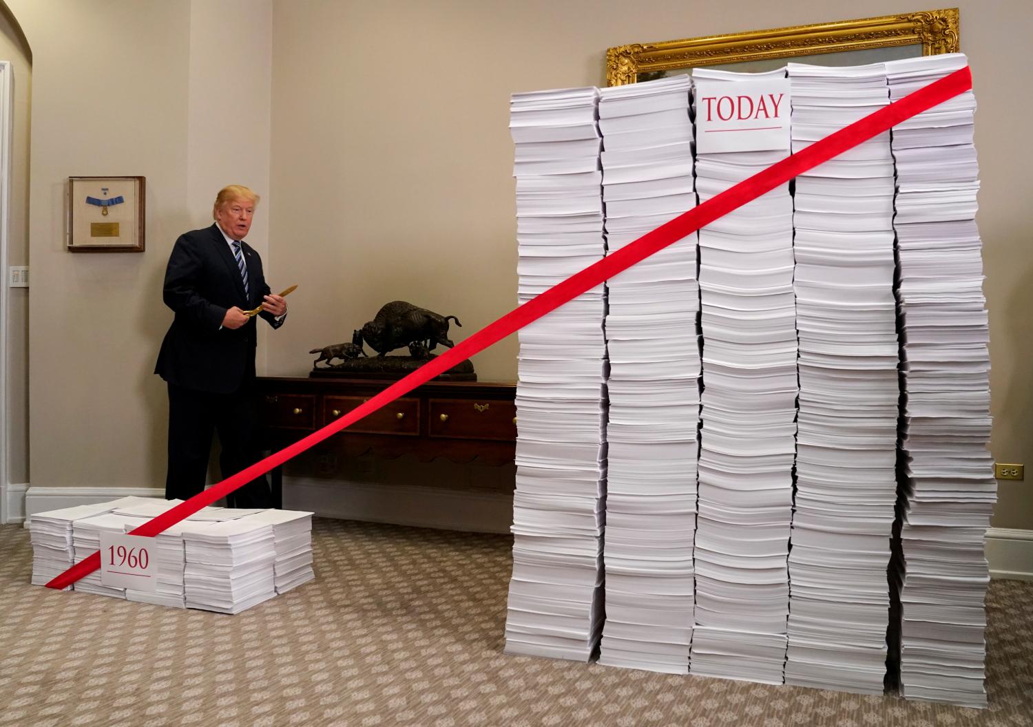 U.S. President Donald Trump prepares to cut a red tape while speaking about deregulation at the White House in Washington, U.S., December 14, 2017. REUTERS/Kevin Lamarque - RC1F03F618F0