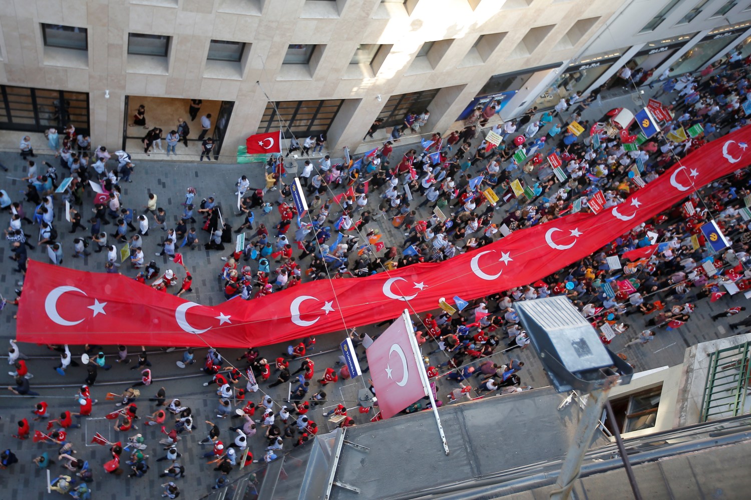 Supporters of Turkish President Tayyip Erdogan carry a huge Turkish flag during a pre-election gathering in Istanbul, Turkey, June 20, 2018. REUTERS/Huseyin Aldemir - RC194386C110