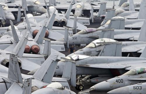 A U.S. Navy personnel walks among F/A 18 aircraft on the flight deck of the USS Theodore Roosevelt at Changi Navy Base in Singapore October 24, 2015. The aircraft carrier and its strike group of 7 ships and 80 aircraft docked in Singapore on Saturday after completing a deployment to the Arabian Gulf for the last 7 months. REUTERS/Edgar Su  - GF20000030490