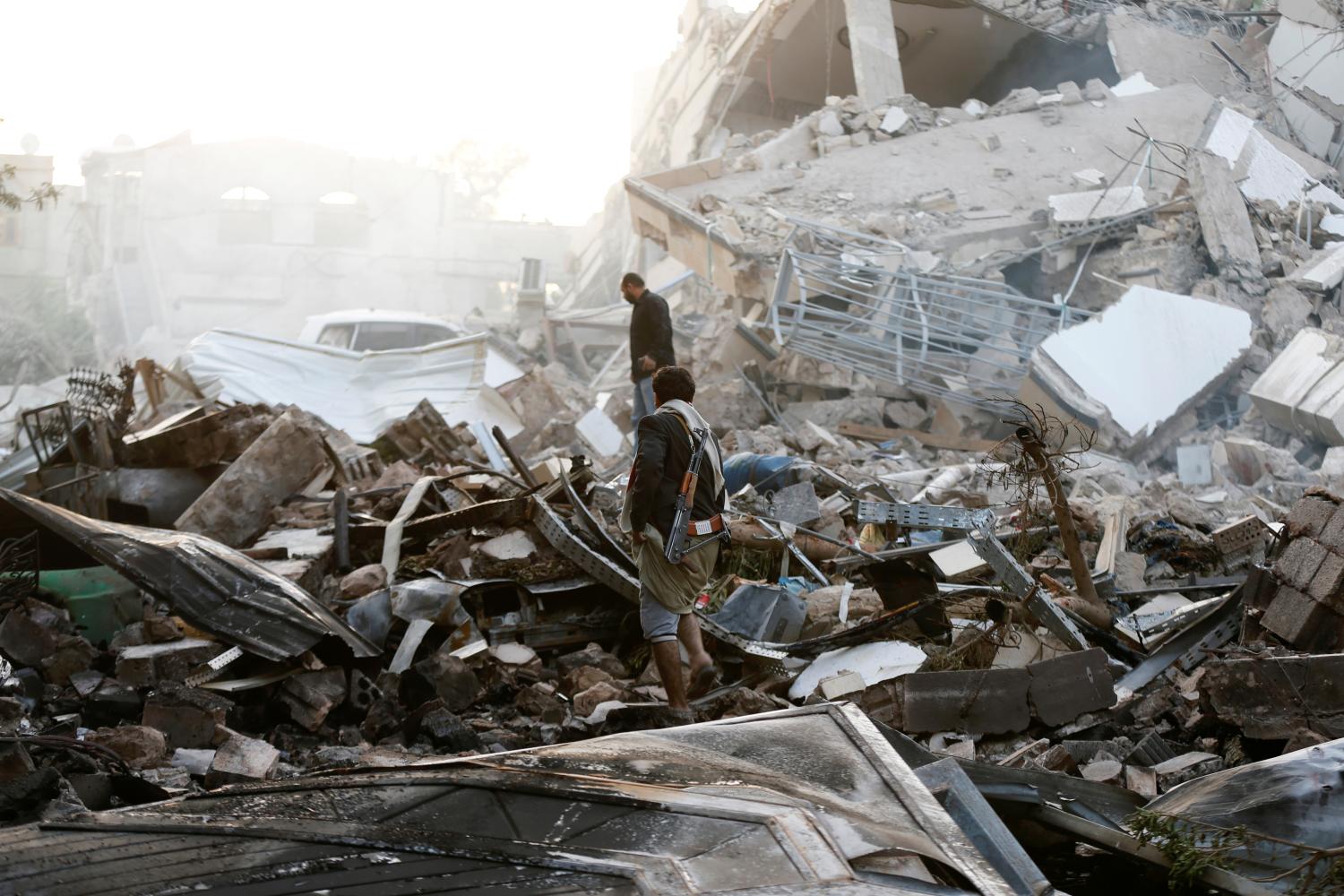 Guards walk on the wreckage of a building destroyed by air strikes in Sanaa, Yemen June 6, 2018. REUTERS/Khaled Abdullah - RC15ACE97640