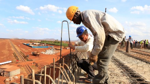 A Chinese engineer and a local construction worker work on a section of the Mombasa-Nairobi standard gauge railway (SGR) in Emali, Kenya October 10, 2015. The China Road and Bridge Corporation (CRBC) tasked with the construction work at a cost of 3.8 billion U.S. dollars is due for completion in mid-2017. REUTERS/Noor Khamis  - D1AERZDORFAA