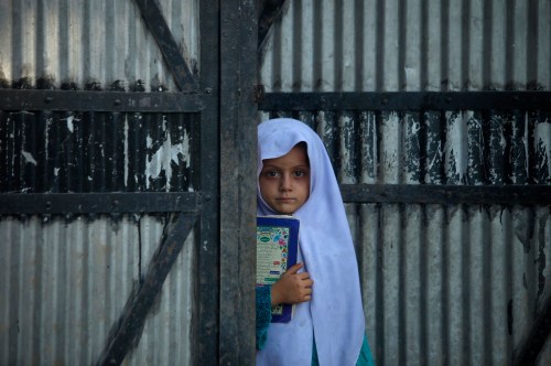 Noreen, a 6-year-old Pashtun girl, holds a book as she stands at the doorway of her family house in the outskirts of Peshawar October 11, 2012.  REUTERS/Fayaz Aziz     (PAKISTAN - Tags: SOCIETY TPX IMAGES OF THE DAY) - GM1E8AB1TKJ01