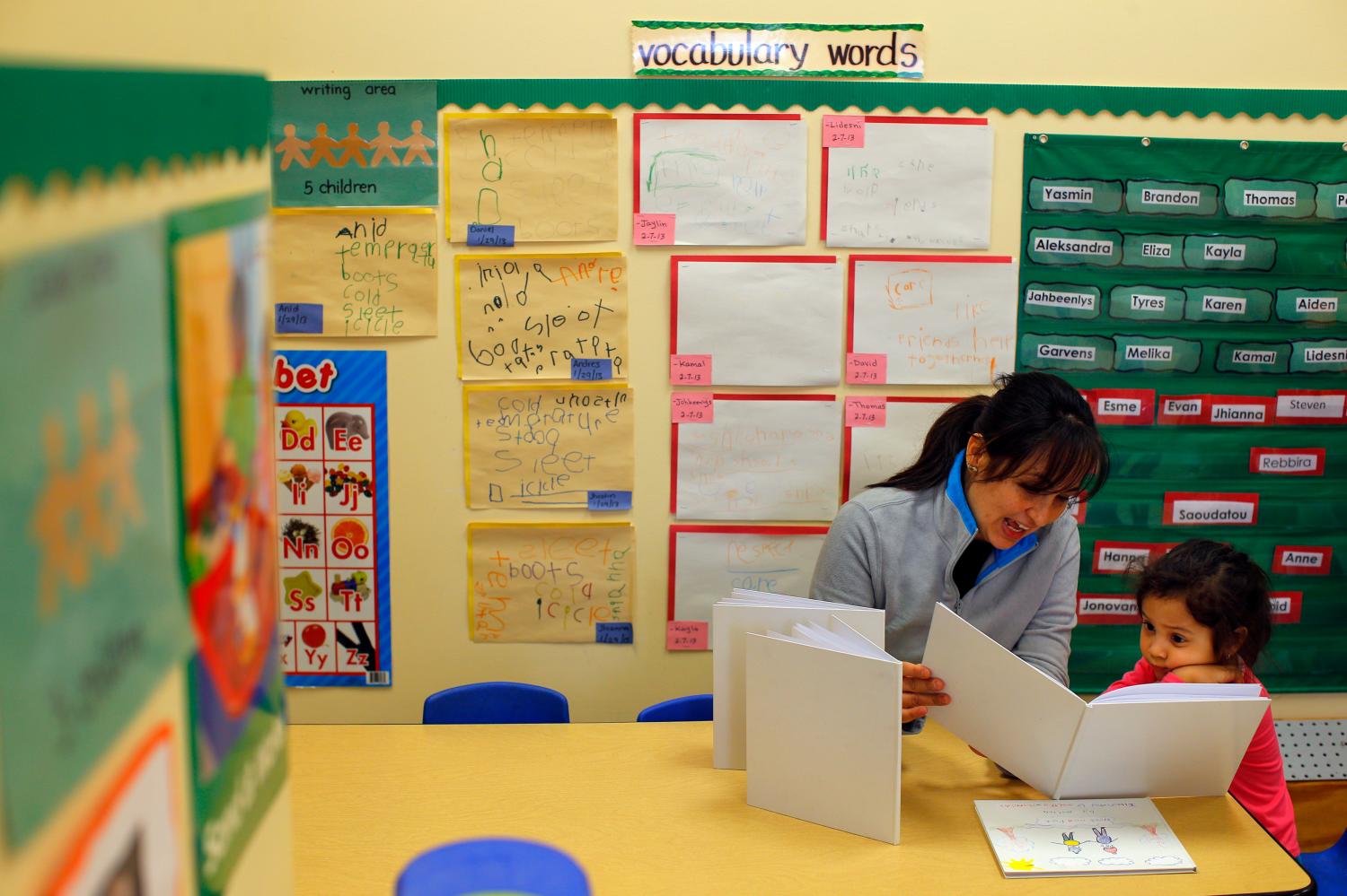 Paola Garcia reads a book with her three-year-old daughter Emily at Action for Boston Community Development's (ABCD) Head Start program in the Roslindale neighborhood of Boston, Massachusetts March 5, 2013. Garcia attends classes to learn English as a second language while her daughter attends Head Start, which provides early learning for children. According to ABCD, 95 percent of the money for the Head Start program comes from the federal government, funding that faces cuts under sequestration. REUTERS/Brian Snyder (UNITED STATES - Tags: POLITICS EDUCATION BUSINESS SOCIETY) - GM1E9360GQG01