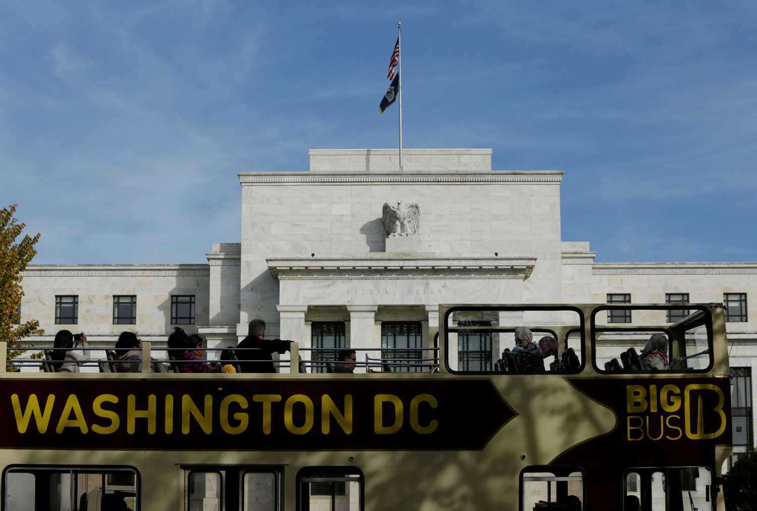 A tour bus passes the United States Federal Reserve Board building (rear) in Washington October 28, 2014. The U.S. Federal Reserve this week will likely reinforce its stated willingness to wait a long while before hiking interest rates after a volatile month in financial markets that saw some measure of inflation expectations drop worryingly low.   REUTERS/Gary Cameron  (UNITED STATES - Tags: BUSINESS POLITICS) - GM1EAAT01TM01