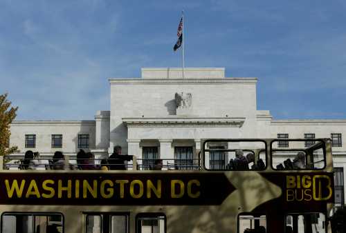 A tour bus passes the United States Federal Reserve Board building (rear) in Washington October 28, 2014. The U.S. Federal Reserve this week will likely reinforce its stated willingness to wait a long while before hiking interest rates after a volatile month in financial markets that saw some measure of inflation expectations drop worryingly low.   REUTERS/Gary Cameron  (UNITED STATES - Tags: BUSINESS POLITICS) - GM1EAAT01TM01