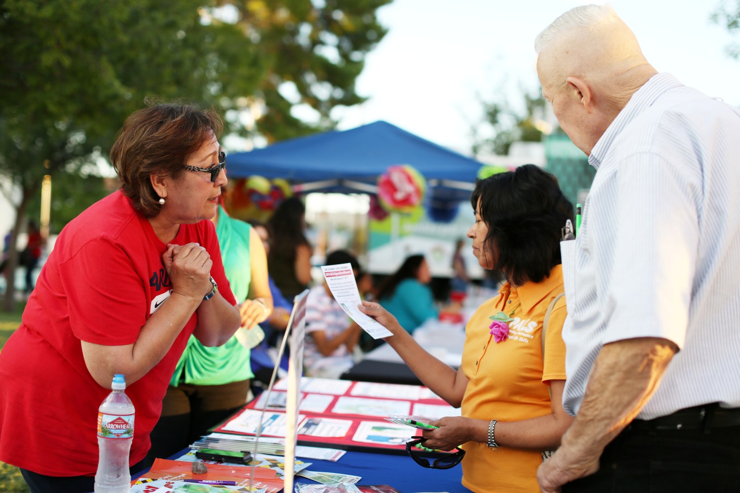 A health insurance navigator explains services at a booth in Arizona