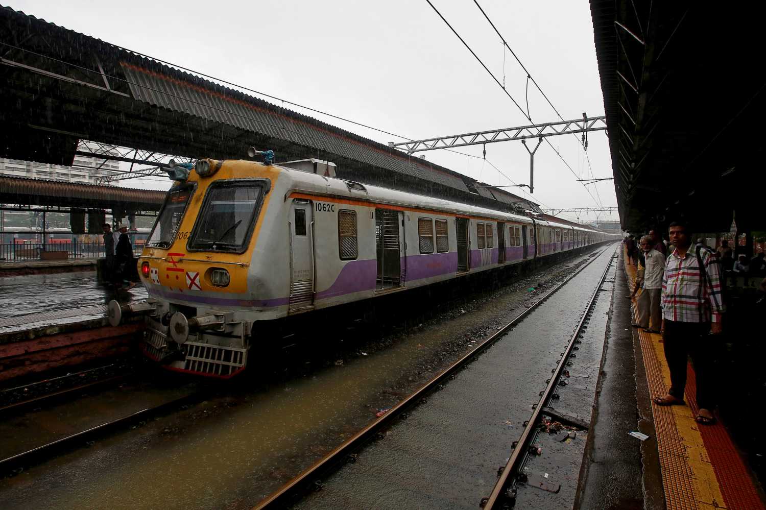 Commuters wait at a railway platform in Mumbai, India.