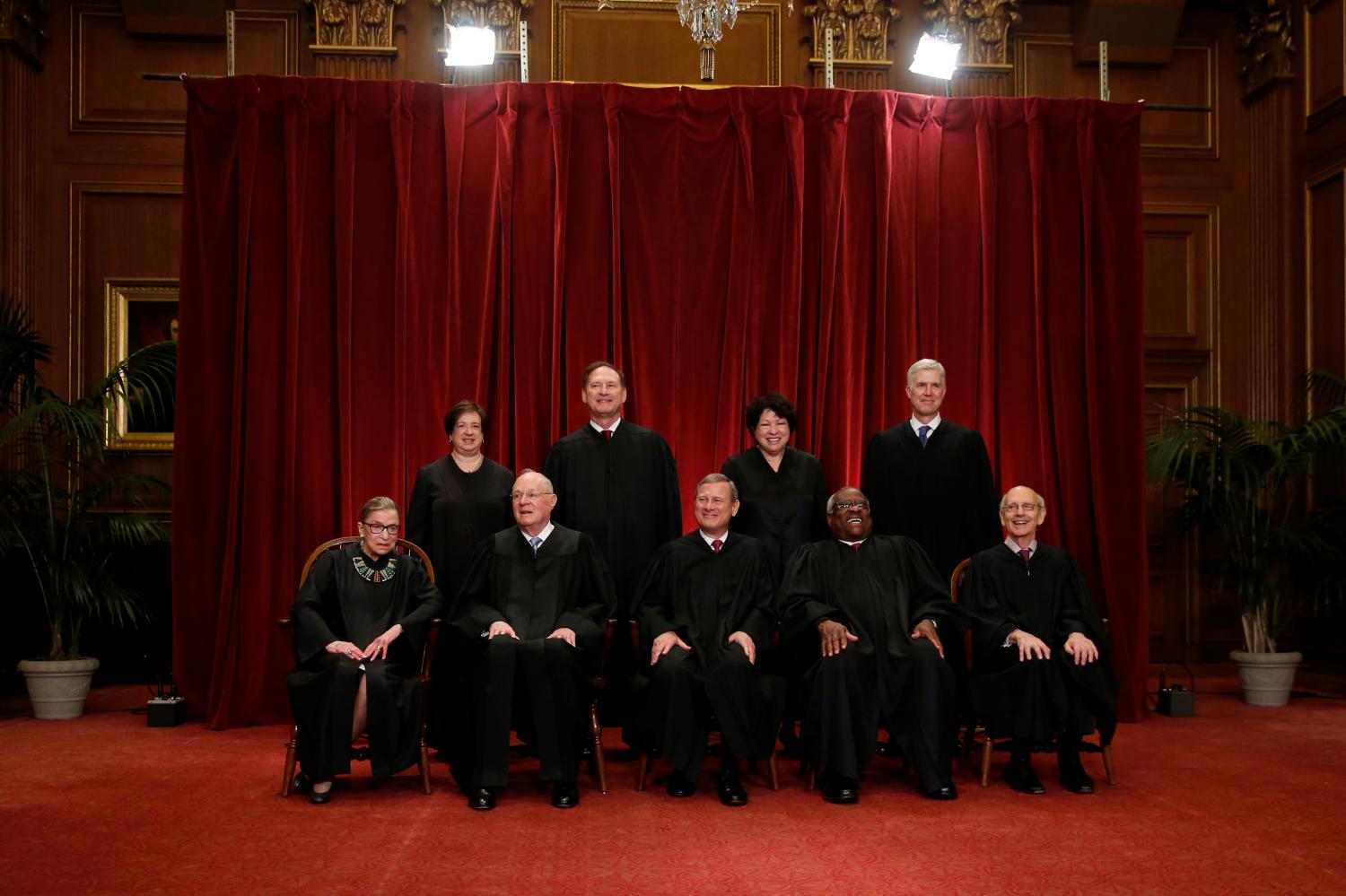 U.S. Chief Justice John Roberts (seated C) leads Justice Ruth Bader Ginsburg (front row, L-R), Justice Anthony Kennedy, Justice Clarence Thomas, Justice Stephen Breyer, Justice Elena Kagan (back row, L-R), Justice Samuel Alito, Justice Sonia Sotomayor, and Justice Neil Gorsuch in taking a new family photo including Gorsuch, their most recent addition, at the Supreme Court building in Washington, D.C, U.S., June 1, 2017. REUTERS/Jonathan Ernst - RC1263640740