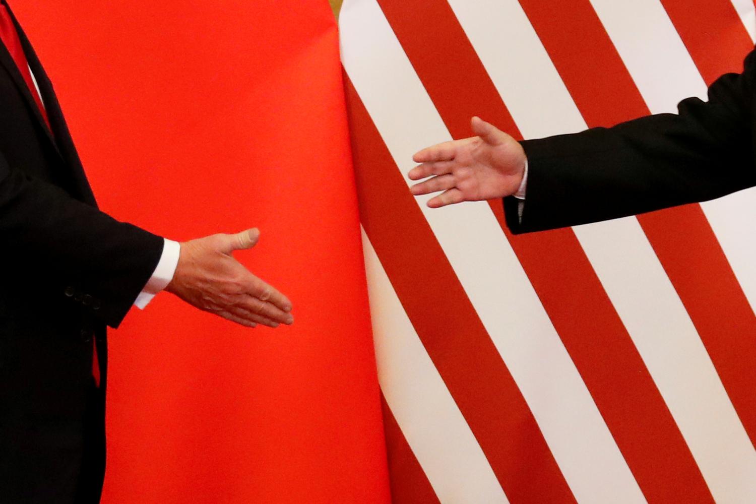 U.S. President Donald Trump and China's President Xi Jinping shake hands after making joint statements at the Great Hall of the People in Beijing, China, November 9, 2017. Damir Sagolj: "It's one of those "how to make a better or at least different shot when two presidents shake hands several times a day, several days in row". If I'm not mistaken in calculation, presidents Xi Jinping of China and Donald Trump of the U.S. shook their hands at least six times in events I covered during Trump's recent visit to China. I would imagine there were some more handshakes I haven't seen but other photographers did. And they all look similar - two big men, smiling and heartily greeting each other until everyone gets their shot. But then there is always something that can make it special - in this case the background made of U.S. and Chinese flags. They shook hands twice in front of it, and the first time it didn't work for me. The second time I positioned myself lower and centrally, and used the longest lens I have to capture only hands reaching for a handshake." REUTERS/Damir Sagolj/File Photo  SEARCH "POY TRUMP" FOR THIS STORY. SEARCH "REUTERS POY" FOR ALL BEST OF 2017 PACKAGES.    TPX IMAGES OF THE DAY - RC1B1E5EF340