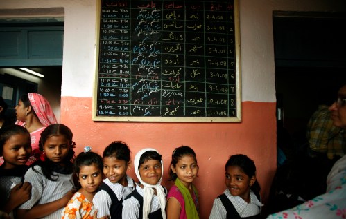 Schoolgirls queue up to receive money from authorities at a government school in Mumbai April 25, 2008. Girls attending state-run schools in India's financial capital of Mumbai are ending the school year a little richer than they began it. For each day a girl showed up in classes, city authorities are paying her 1 rupee -- about 2 U.S. cents. Boys continue to take nothing home besides their homework. Picture taken April 25, 2008 REUTERS/Punit Paranjpe (INDIA)Also see: GF2E46U0SUZ01 - GM1E44S1ESO01
