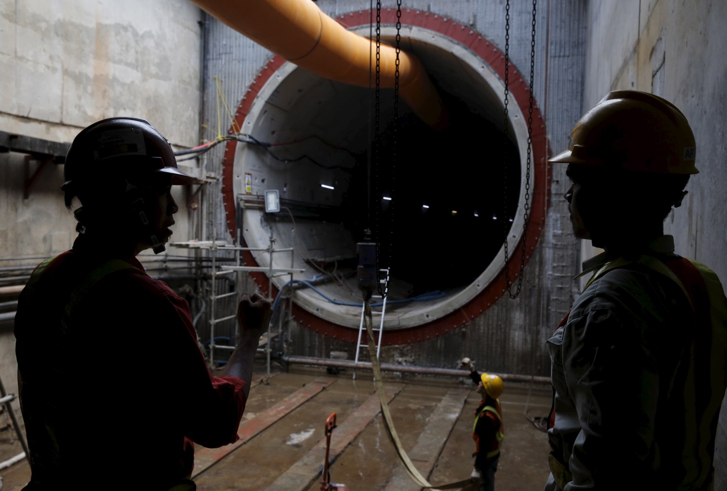 Construction workers stand near an underground MRT (Mass rapid transit system) tunnel in Jakarta