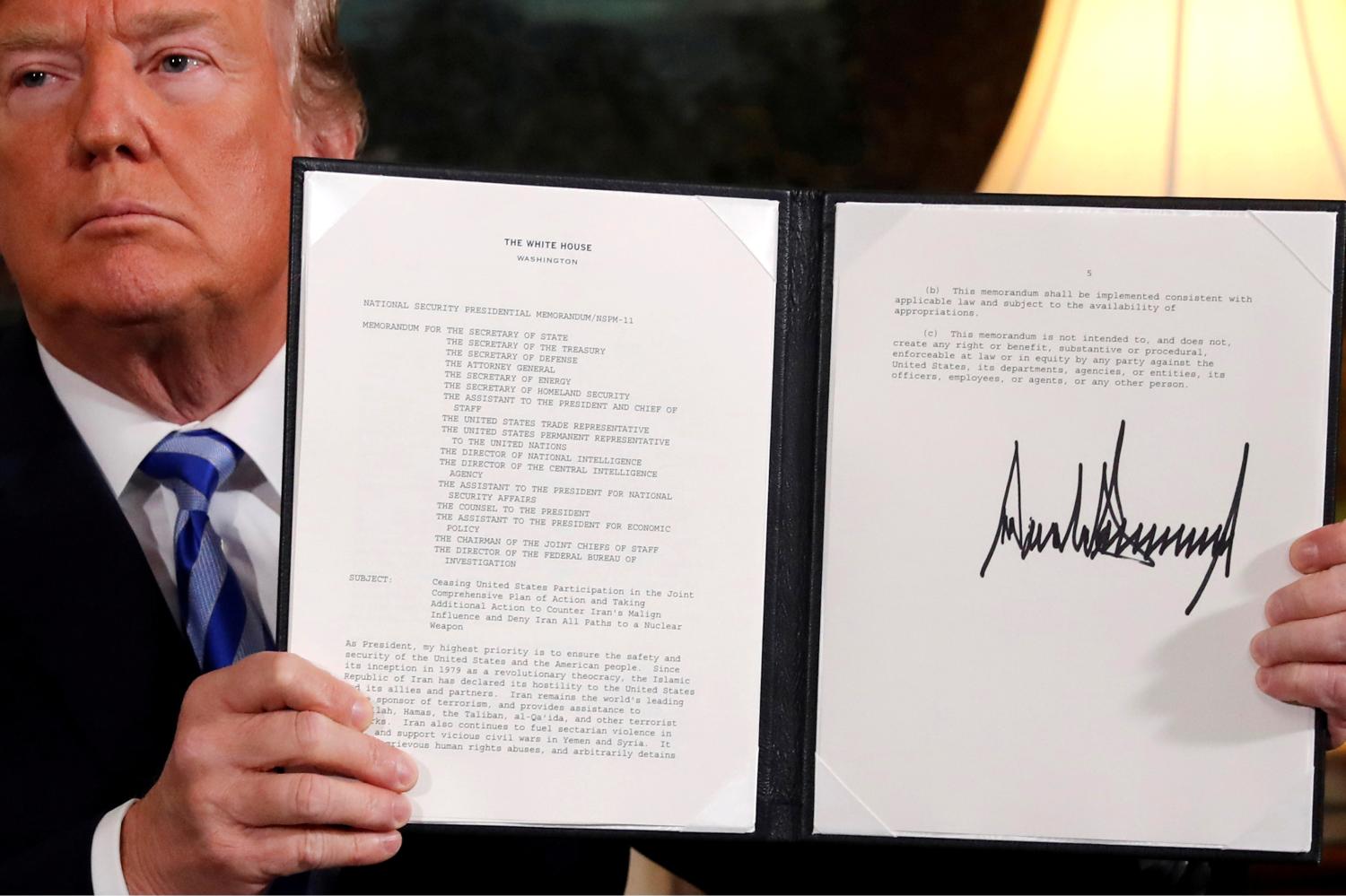 U.S. President Donald Trump holds up a proclamation declaring his intention to withdraw from the JCPOA Iran nuclear agreement after signing it in the Diplomatic Room at the White House in Washington, U.S. May 8, 2018. REUTERS/Jonathan Ernst