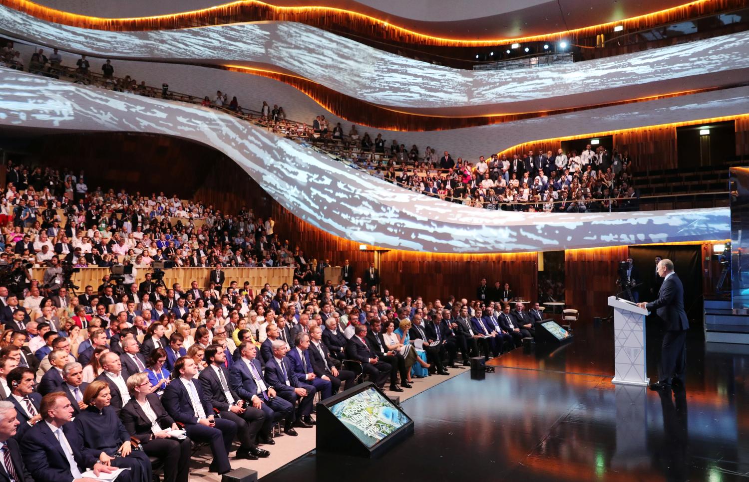 Participants listen to Russia's President Vladimir Putin during a session of Moscow Urban Forum 2018 at the Concert Hall of Zaryadye Park in Moscow, Russia July 18, 2018. Sputnik/Mikhail Klimentyev/Kremlin via REUTERS  ATTENTION EDITORS - THIS IMAGE WAS PROVIDED BY A THIRD PARTY. - RC142E176000