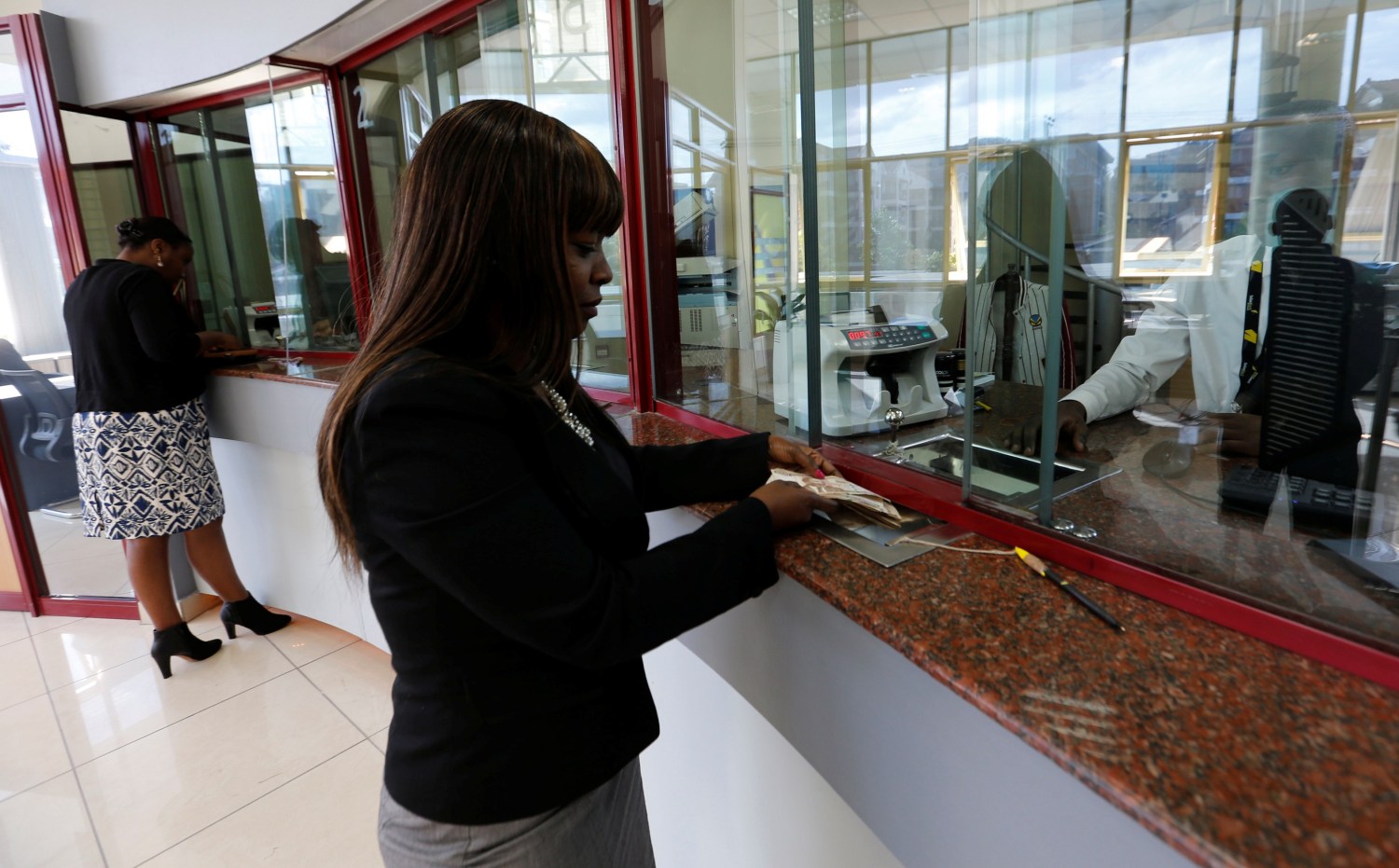 A customer is served at the teller counter inside the banking hall at Kenya's Sidian Bank headquarters on the outskirts of Kenya's capital Nairobi, June 29, 2016.  Picture taken June 29, 2016. REUTERS/Thomas Mukoya  - S1AETMWQMVAB