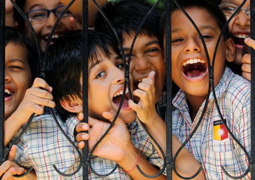 Boys react to the camera during their recess break in the middle of their academic day at a school in Mumbai August 10, 2010. The Right to Education Act that came into force has made free and compulsory education the right of every child between the age of 6 to 14 years old in India. UNESCO says the Act has brought the country closer to meeting its millennium development goals, with an estimated eight million out-of-school Indian children now having better access to education. REUTERS/Danish Siddiqui (INDIA - Tags: EDUCATION) - GM1E68A1UHJ01