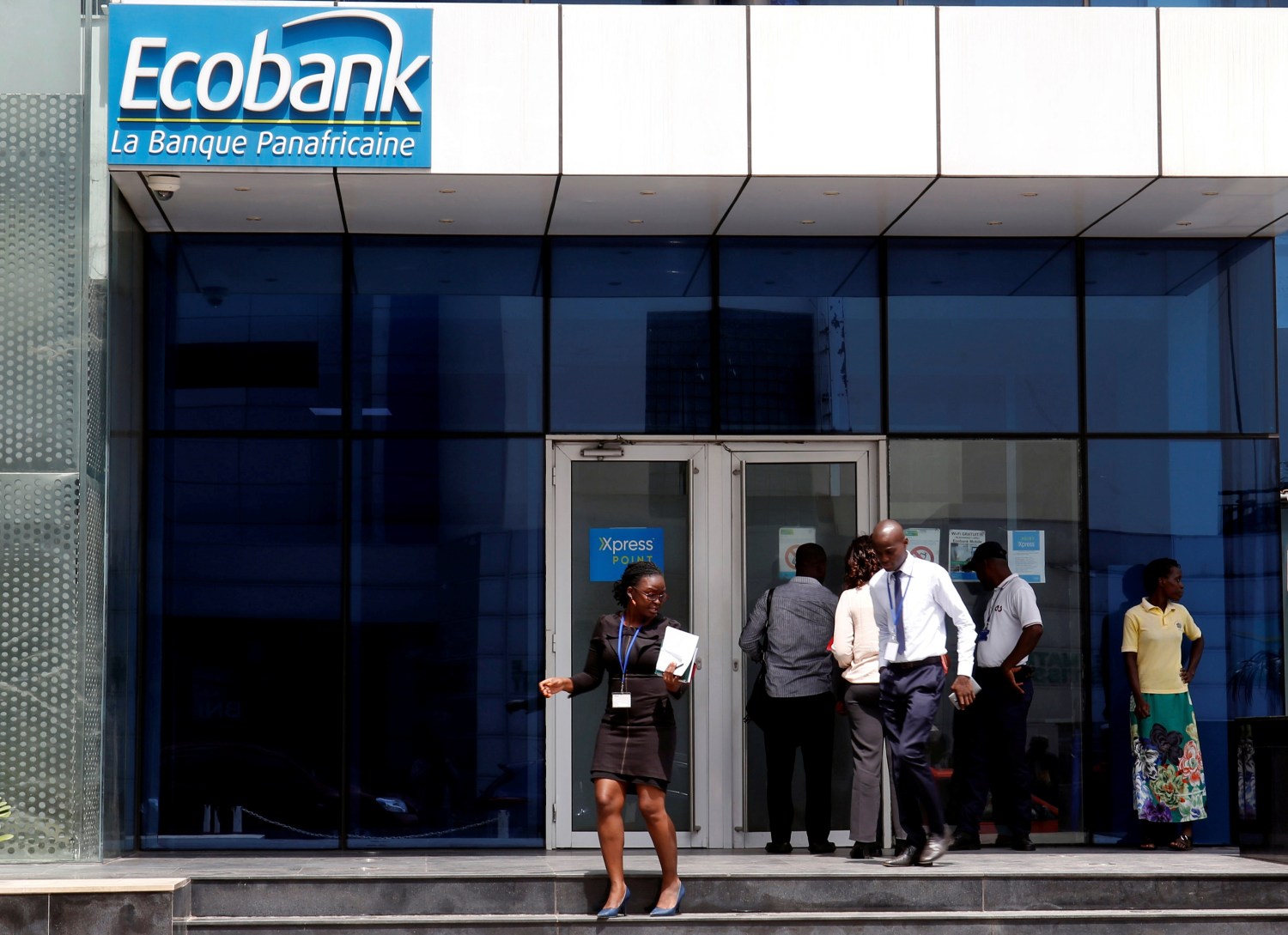 FILE PHOTO: People walk at the entrance of Ecobank building in Abidjan, Ivory Coast June 4, 2018. Picture taken June 4, 2018. REUTERS/Luc Gnago/File Photo - RC1745900630