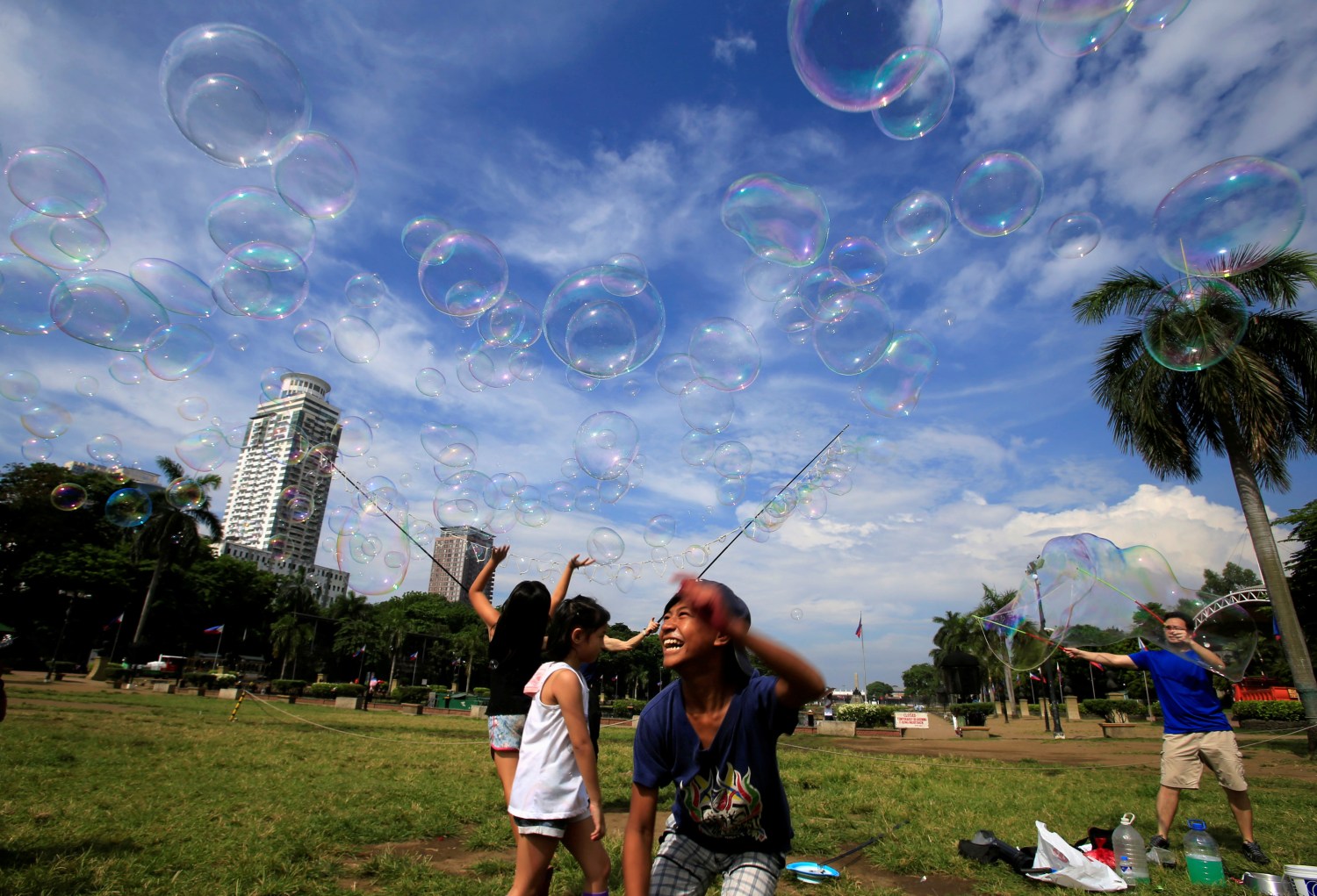 Children play with soap bubbles created by a street performer at Rizal park in Luneta, metro Manila, Philippines May 16, 2018. REUTERS/Romeo Ranoco     TPX IMAGES OF THE DAY - RC19387EB200