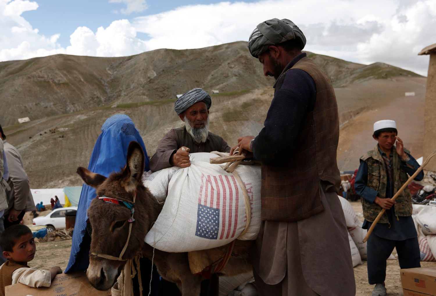 Displaced Afghans load aid near the site of a landslide at the Argo district in Badakhshan province May 5, 2014. Grief-stricken and desititute Afghan villagers vented anger with their government as they scrambled for emergency aid, three days after deadly landslides engulfed their homes. Some 300 homes in Aab Bareek, a village in the Argo district of Badakhshan, a remote and mountainous northeastern province, were buried under up to 50 metres of earth and debris. REUTERS/Mohammad Ismail (AFGHANISTAN - Tags: DISASTER) - GM1EA56055K01