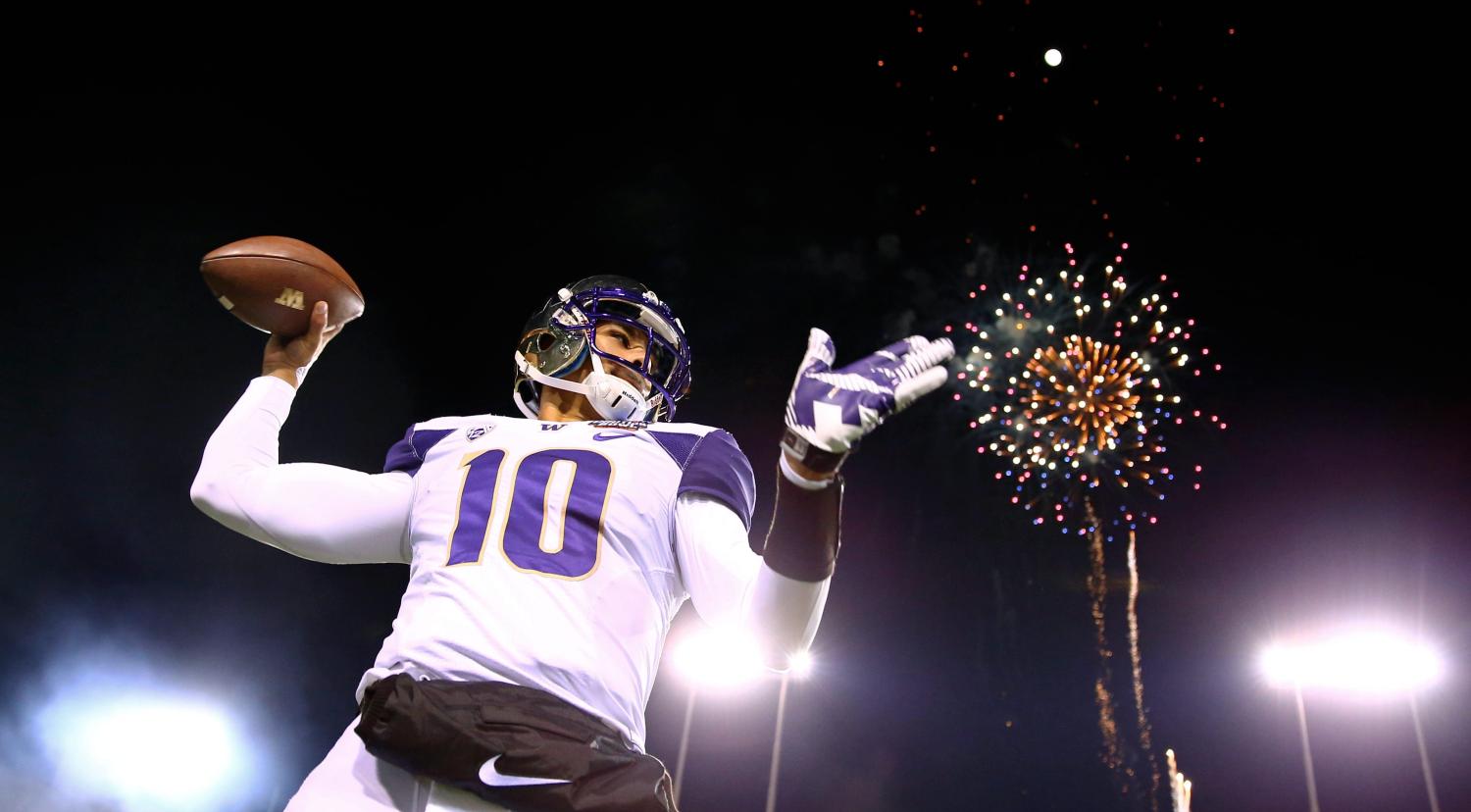 Fireworks explode behind Washington Huskies quarterback prior to a game.