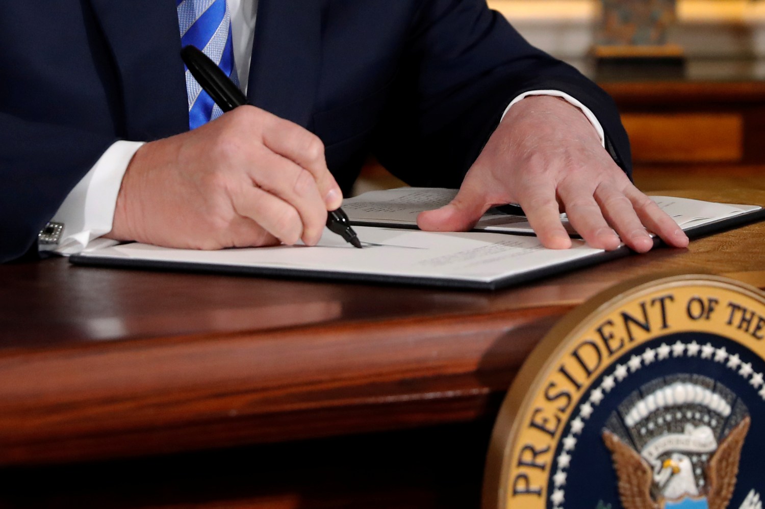U.S. President Donald Trump signs a proclamation declaring his intention to withdraw from the JCPOA Iran nuclear agreement in the Diplomatic Room at the White House in Washington, U.S. May 8, 2018.  REUTERS/Jonathan Ernst - RC173F474E20