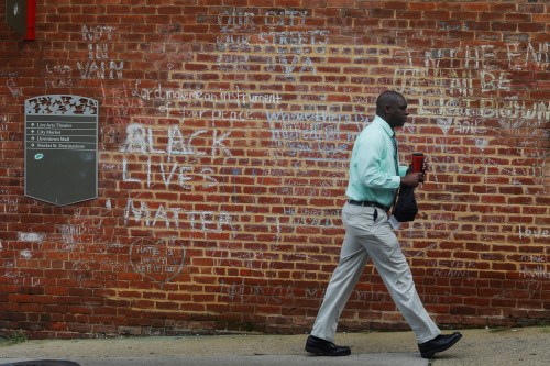 A man walks past tributes written at the site where Heather Heyer was killed during the 2017 white-nationalist rally in Charlottesville, Virginia, U.S., August 1, 2018.  Picture taken August 1, 2018. REUTERS/Brian Snyder - RC19E176BEC0