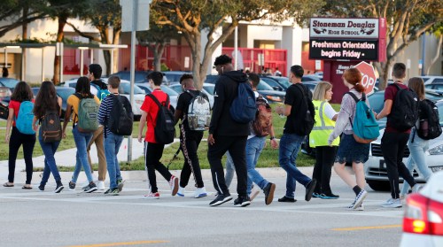 Students cross a street to enter for the first day of classes at Marjory Stoneman Douglas High School in Parkland, Florida, U.S. August 15, 2018.  REUTERS/Joe Skipper - RC1EFE4D0510
