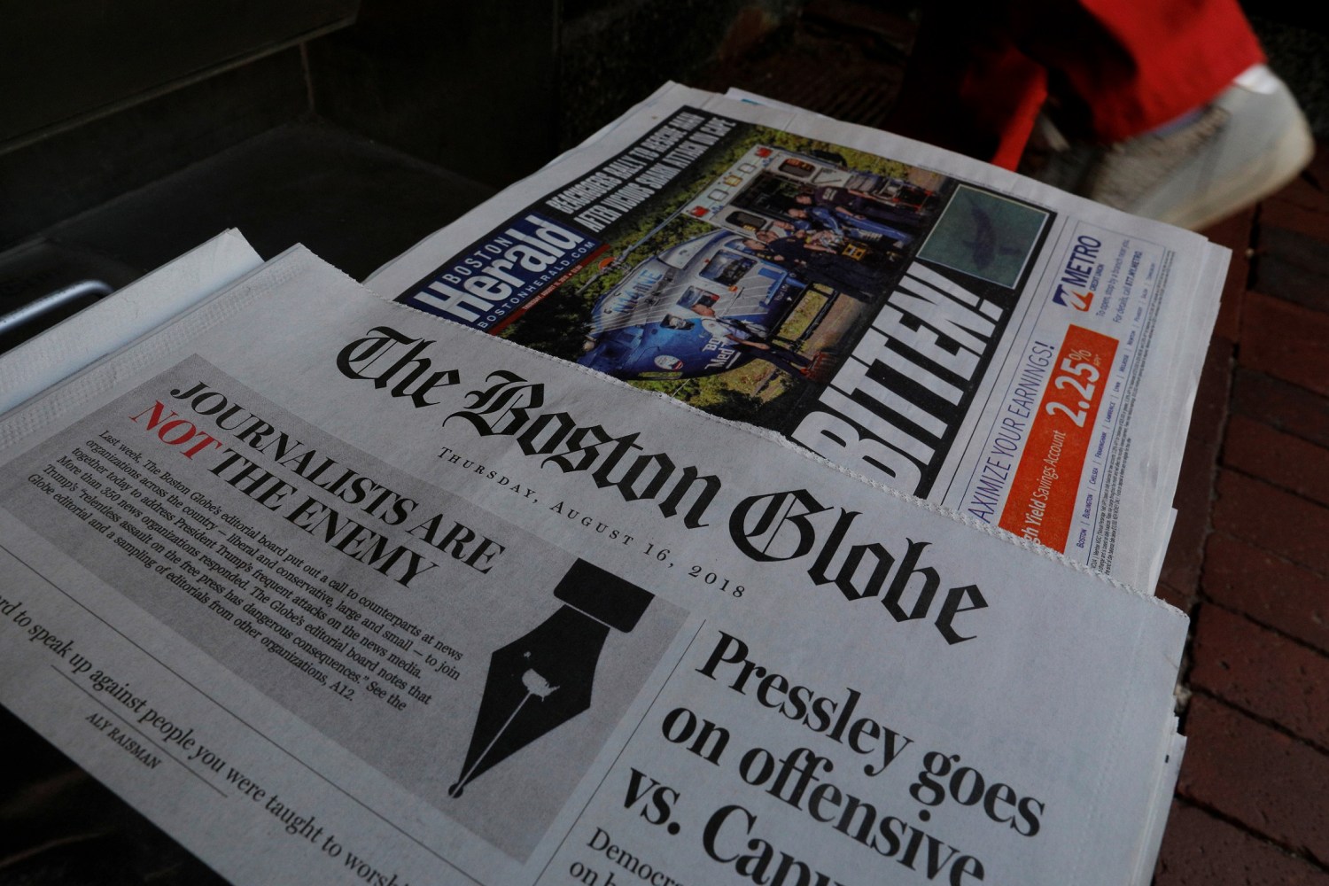 A customer walks past the front page of the Boston Globe newspaper referencing their editorial defense of press freedom and a rebuke of President Donald Trump for denouncing some media organizations as enemies of the American people, part of a nationwide editorial effort coordinated by the Boston Globe, at a newsstand in Cambridge, Massachusetts, U.S., August 16, 2018.     REUTERS/Brian Snyder - RC13AB4553F0